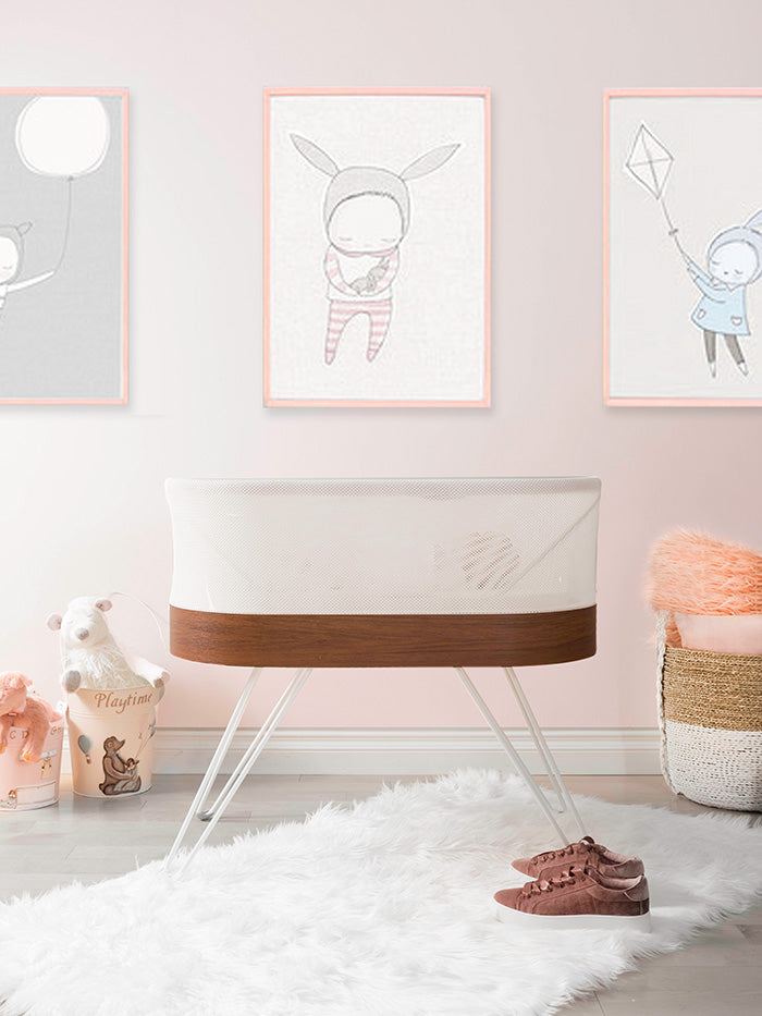 baby nursery with SNOO bassinet and pink wall