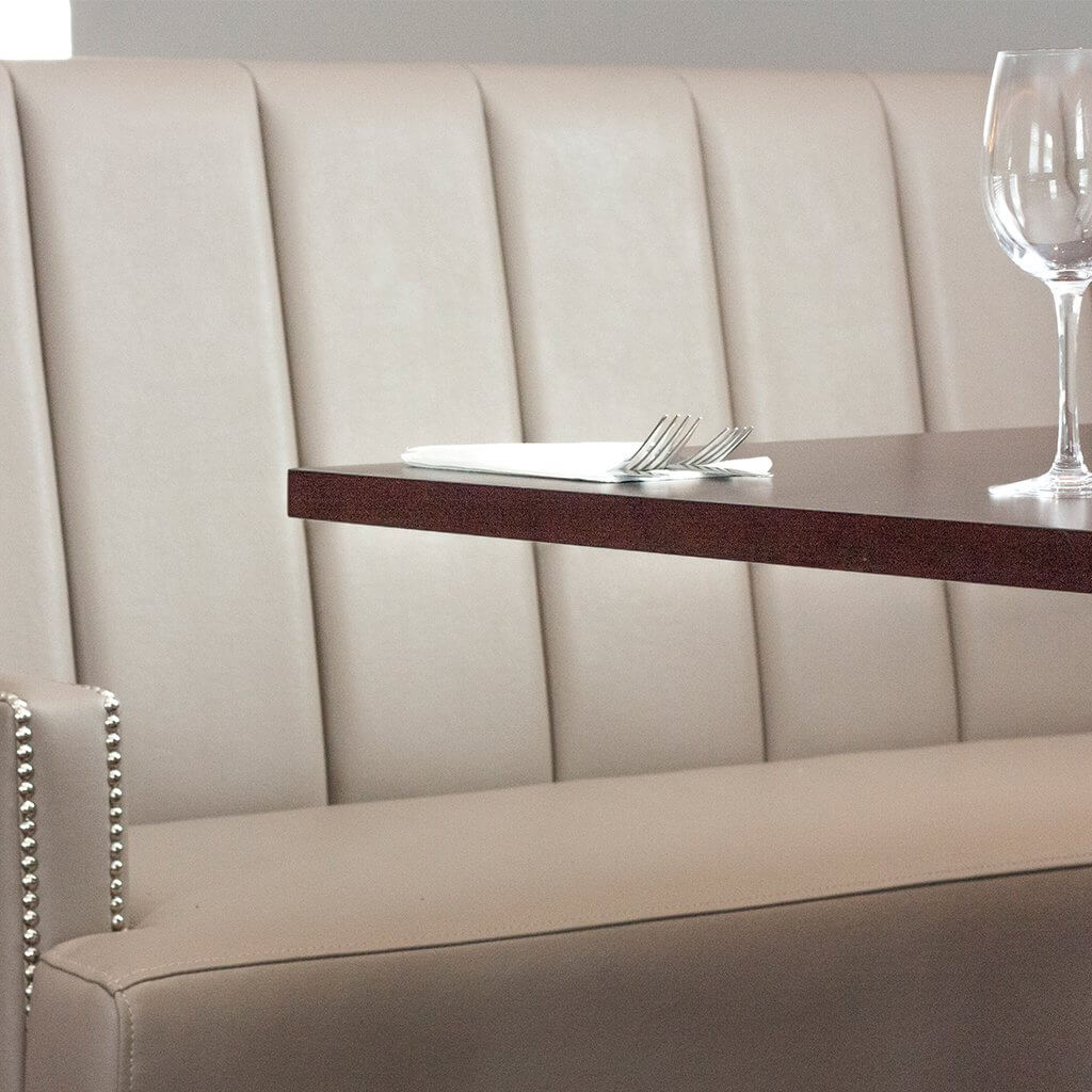 Beige faux leather banquette design with stud detail to arms
