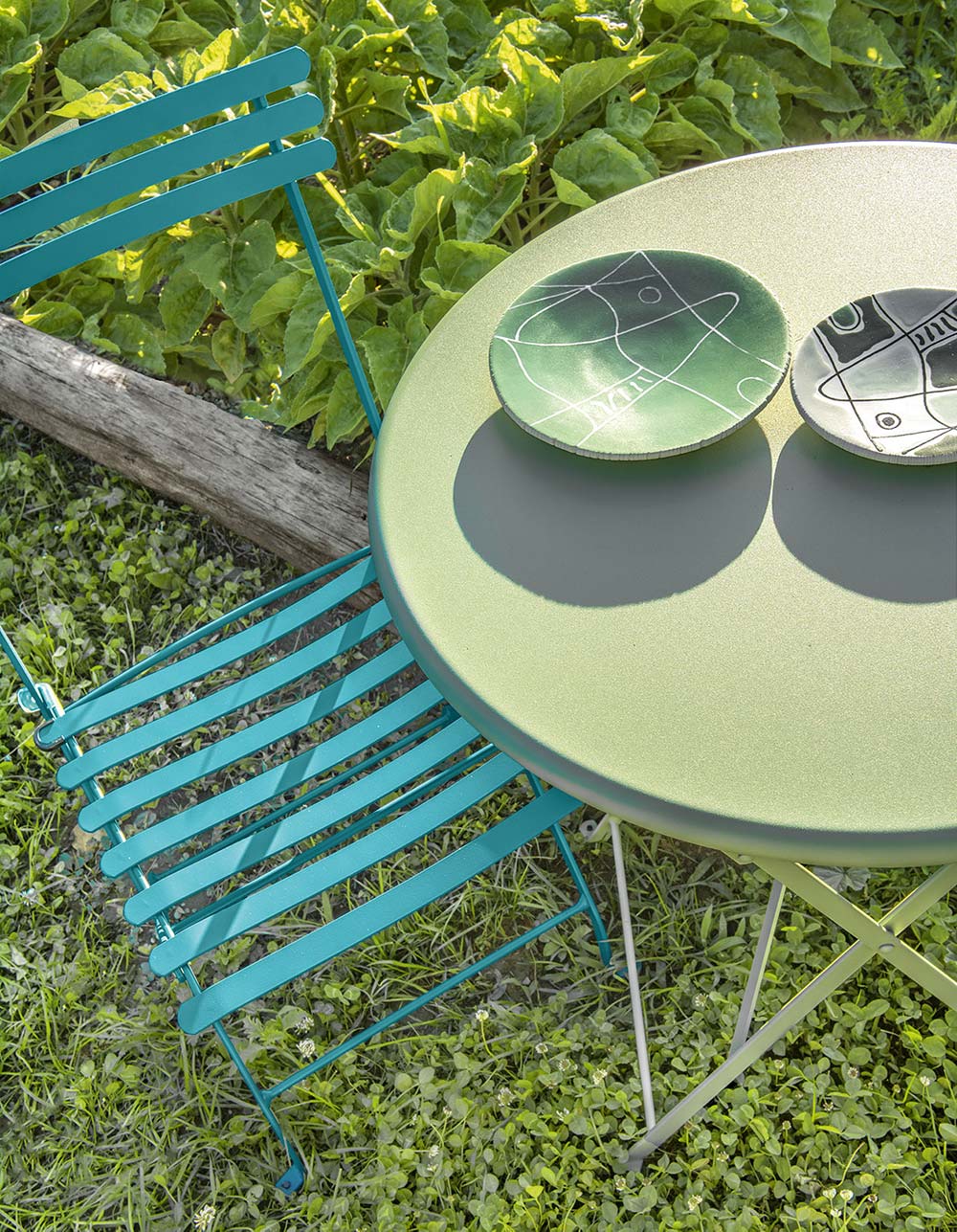 Ethimo colorful metal folding bistro tables and chairs on outdoor patio