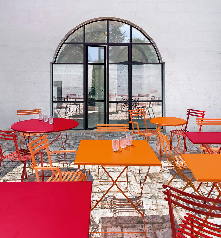 Ethimo colorful metal folding bistro tables and chairs on outdoor patio