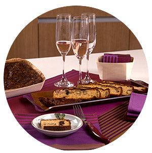 champagne and olive bread with eggplant purple striped napkins and serving tray