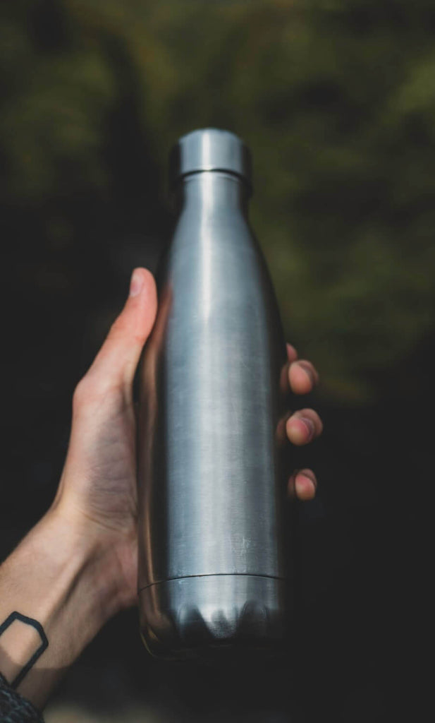 hand holding stainless steel gray water bottle top view