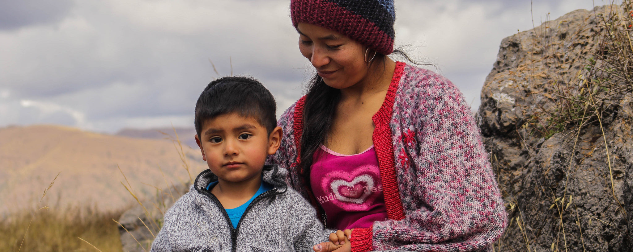 Mother and son sitting on mountain