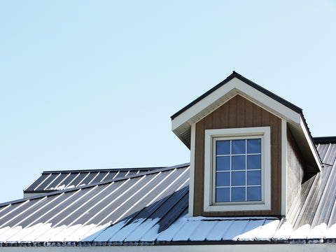 Brown house with snow on the metal roof