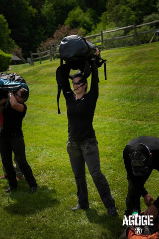 Rachel Lotz carries lifts her Rockagator AGOGE pack over her head in an endurance challenge
