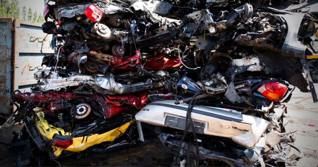 A pile of cars that have been flatted in a junkyard