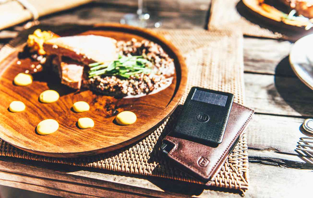 Plate of food with the Parliament Wallet and Wallet Tracker set on the table beside it