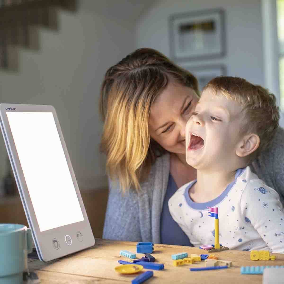 Mother and son in front of a happylight