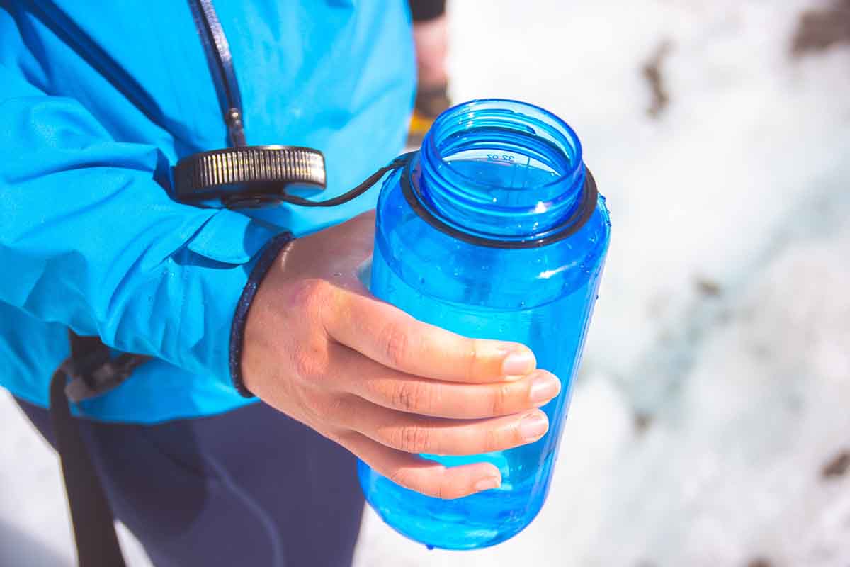 Runner holding blue reusable water bottle