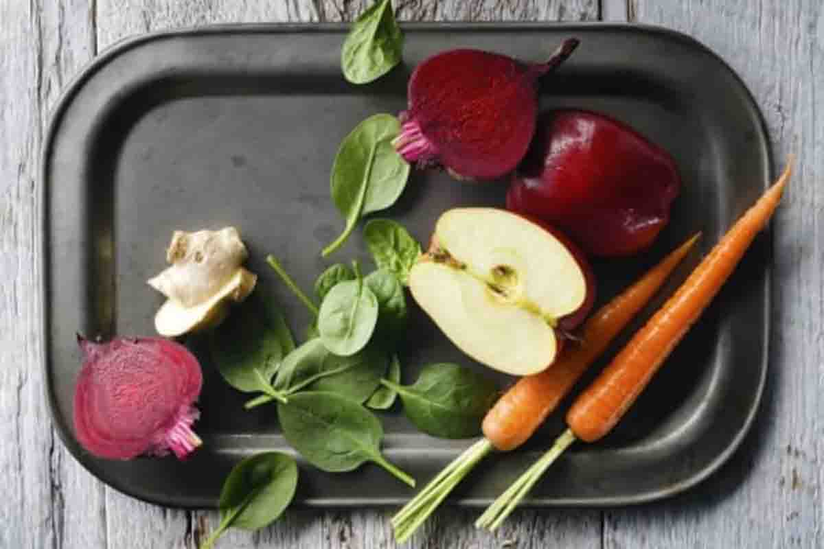 Sliced fruit and vegetables on a black serving platter