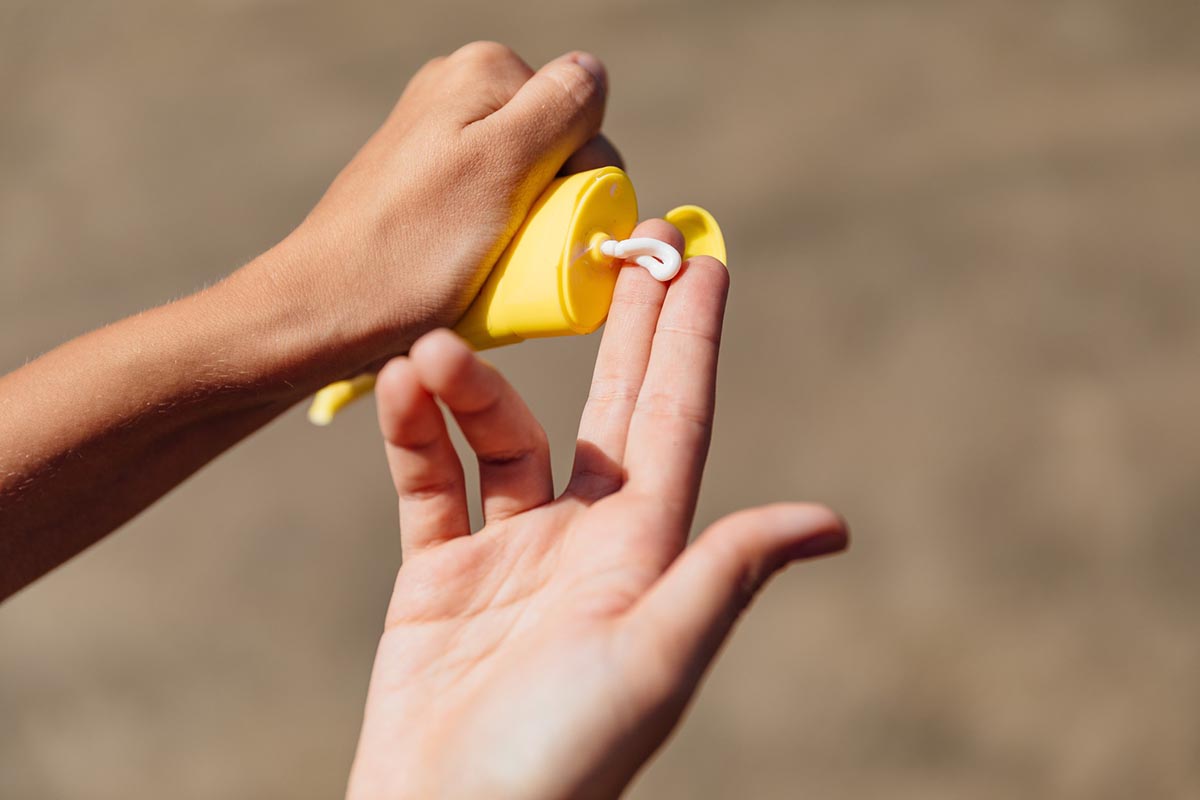 Person putting on sunscreen on their hand