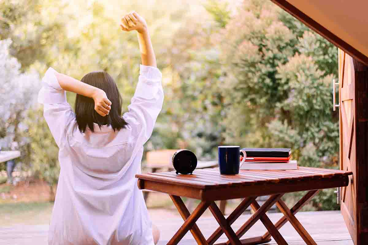 Woman stretching next to low table with tea