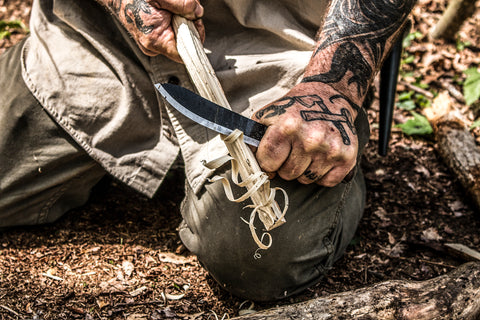 A survival knife being used to make a feather stick - PKS Buffalo Skinner