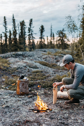 image of man starting a fire in the wilderness 