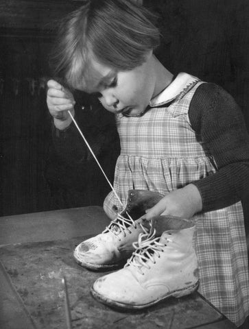 Girl lacing up hi-top shoes