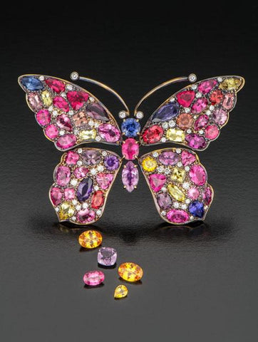 Gold butterfly with Tanzanian sapphires, spinels and garnets, accompanied by loose purple spinel, pink spinel and yellow sapphire. Courtesy of Akiva Gil Co. Photo by Robert Weldon/GIA.