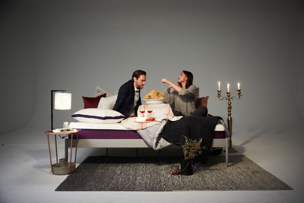 A couple is eating pasta on the Polysleep mattress