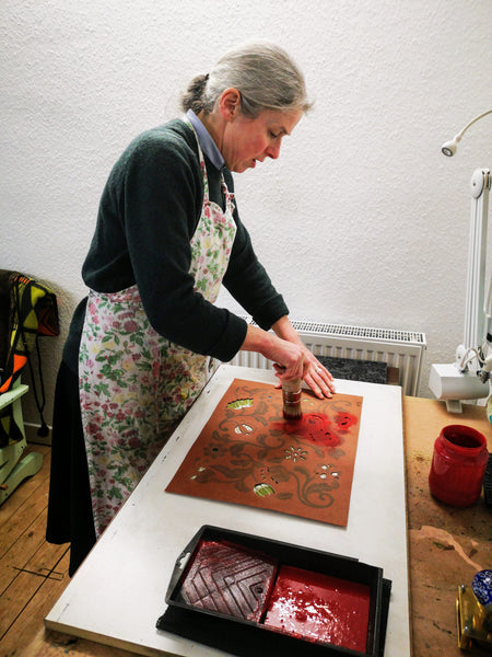 Jane Jeffery applying red paste ink through a stencil