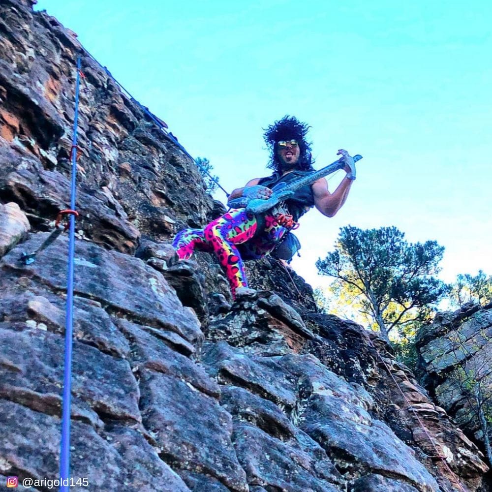 Playing guitar on a cliff in multicolor mens leggings