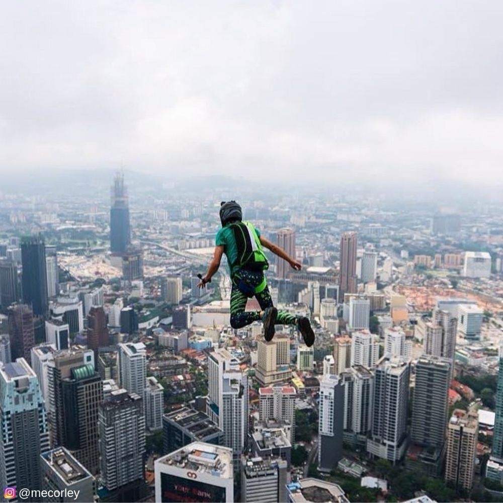 Man base jumping off cliff in male leggings