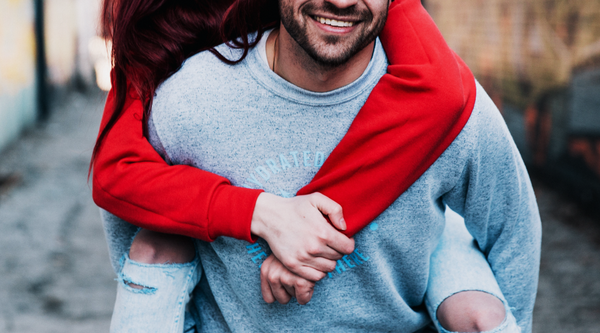 couple in sweaters piggybacking together