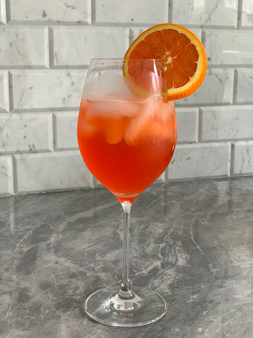 Picture of a glass of aperol spritz on a carrera marble counter
