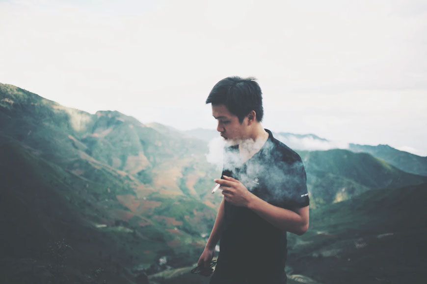 A man smoking while on a hike