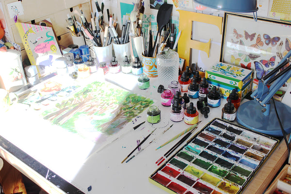 Emily MacKenzie's desk with inks and watercolours