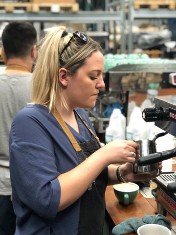 blonde girl making coffee at extract coffee in blue top