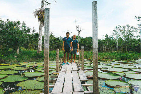 Two men with lights over pond.