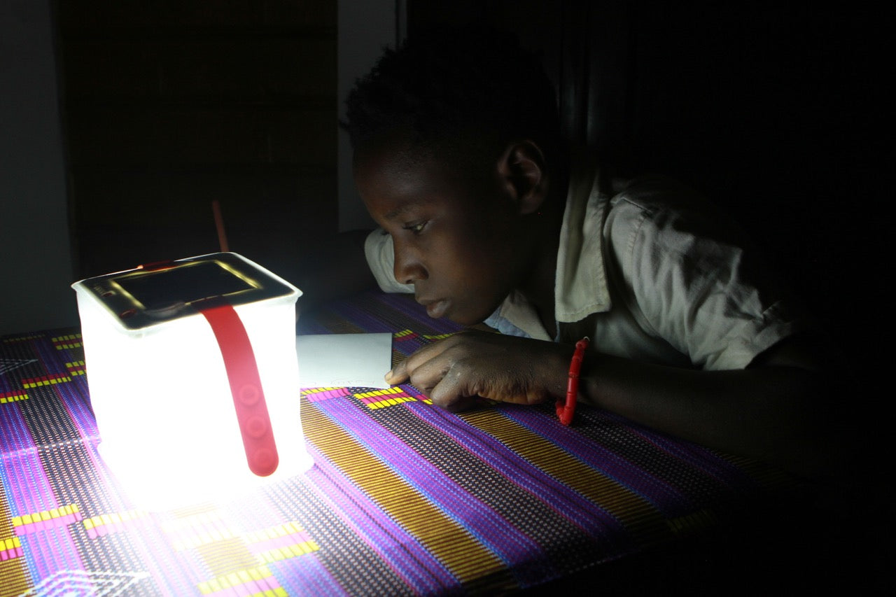 Child using light to do homework at night.