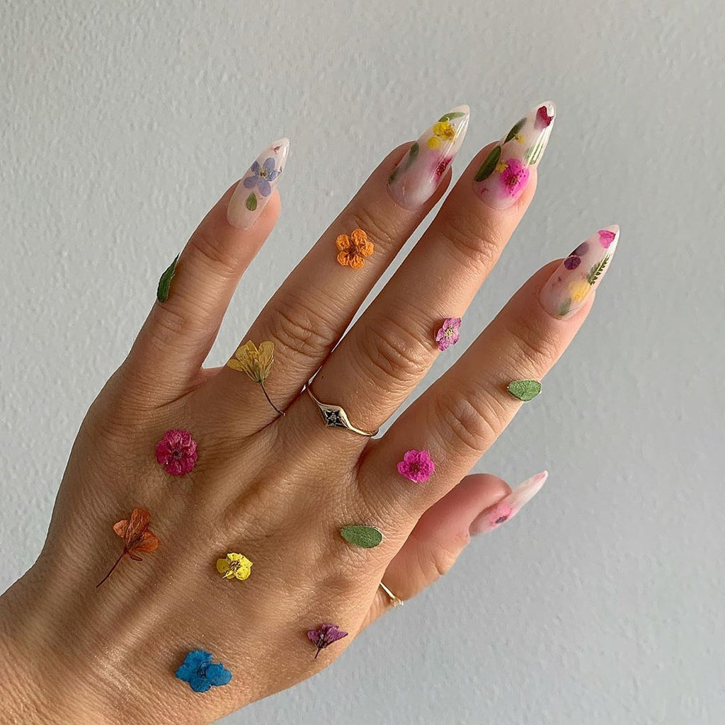 Hand with flowers all over to showcase nail art.