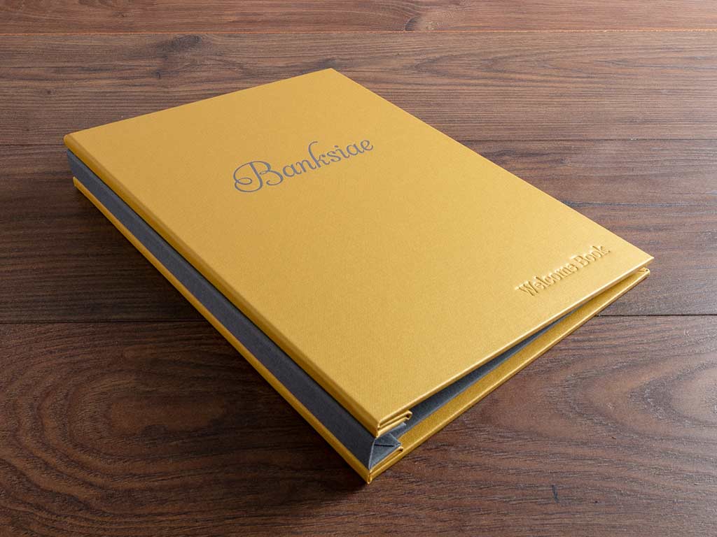 Bespoke visitors information book or folder in gold buckram with platinum buckram spine cover