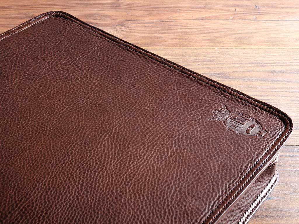 embossed logo on the cove of a custom made leather document portfolio