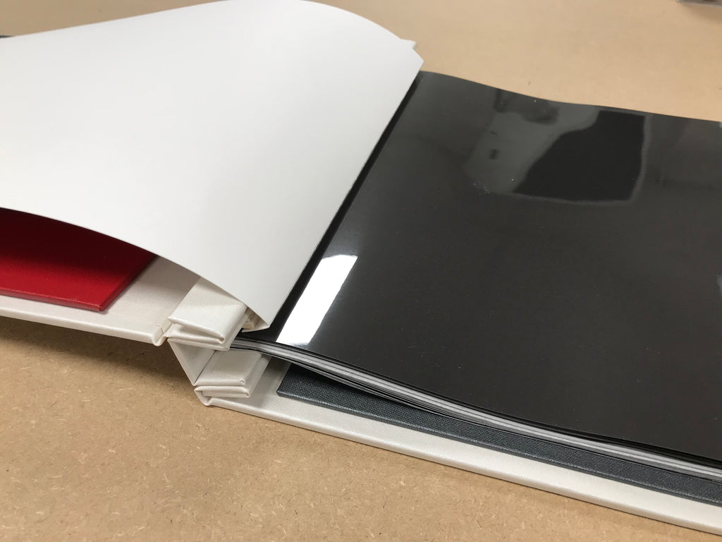 a print portfolio book with a scored page attached with hing strips