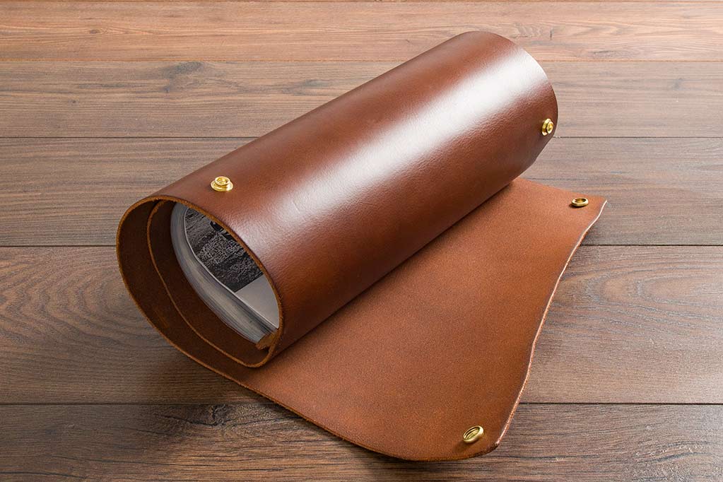 brown leather scroll with metal popper fastenings 