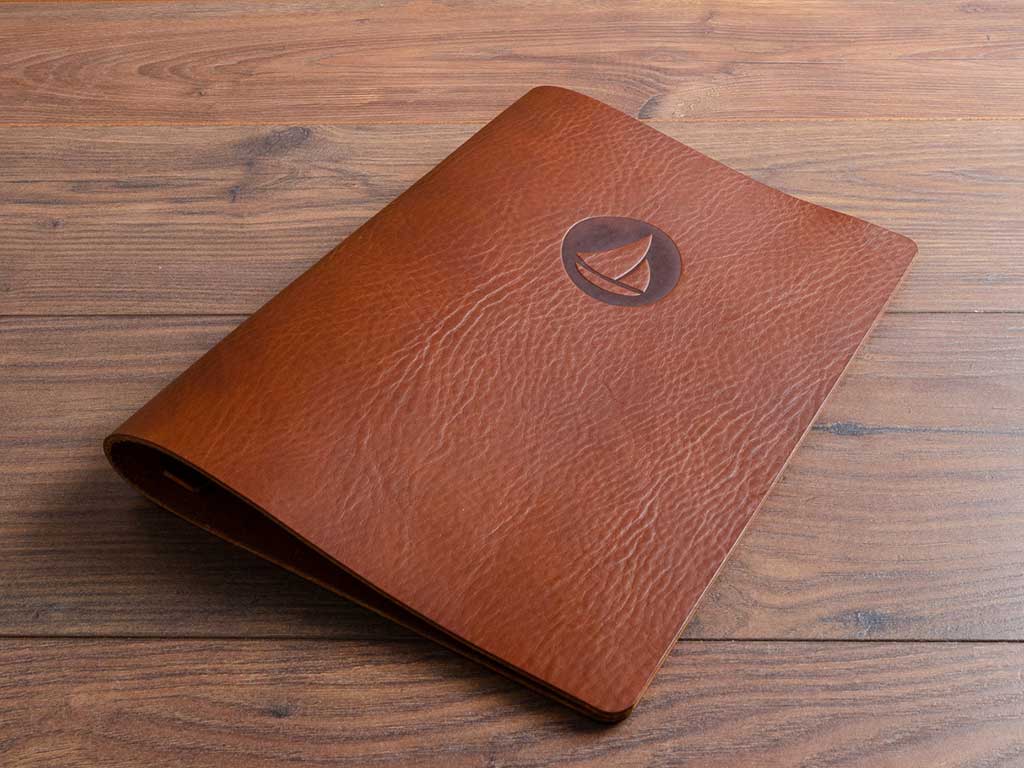 brown leather a4 menu with personalised blind embossing on the cover by hartnack and co