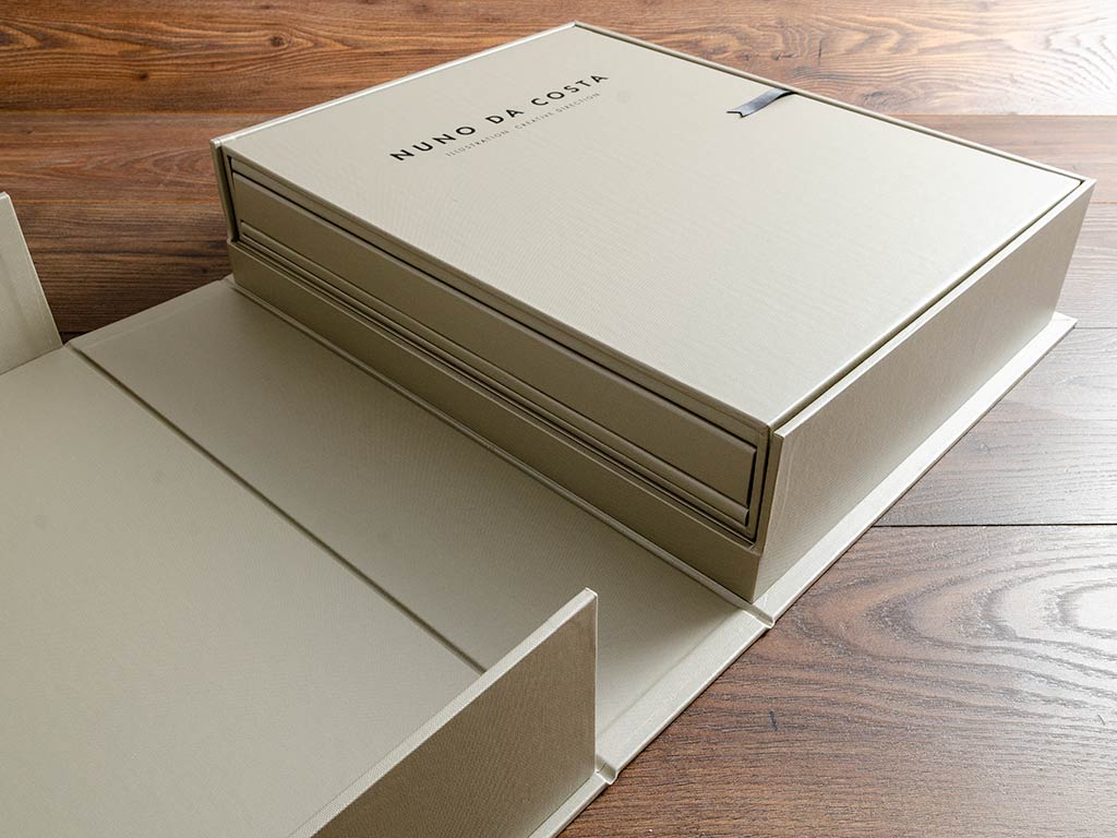Illustrators portfolio book housed within a slipcase sitting on a shelf in a clamshell box
