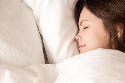 image of woman cuddled up in blanket sleeping.