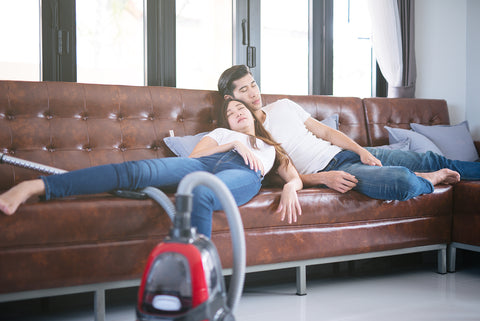 Photo of a young couple napping on the couch.
