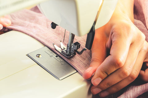 photo of a sewing machine and a hand sewing fabric.