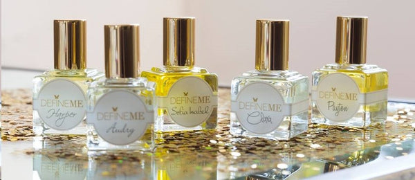 DefineMe Fragrance Oils bottles in a row on gold glitter.