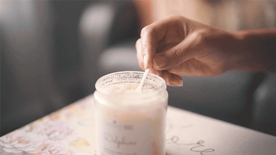 A woman using a spoon to scoop out DefineMe Whipped Body Polish and rubbing it into her skin.
