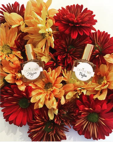 DefineMe Fragrance Harper and Payton oils with red and orange flowers.