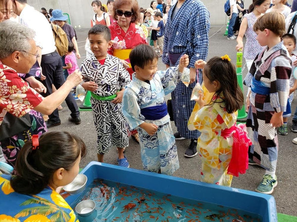 Children in traditional yukata playing games at a bon festival