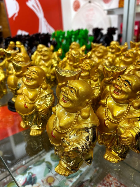 Rows of gold-colored Budai figurines holding an ingot and a magical gourd