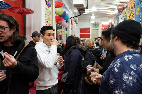 Guests enjoying drinks at Jerry Ma's opening reception for his art show at Pearl River Mart