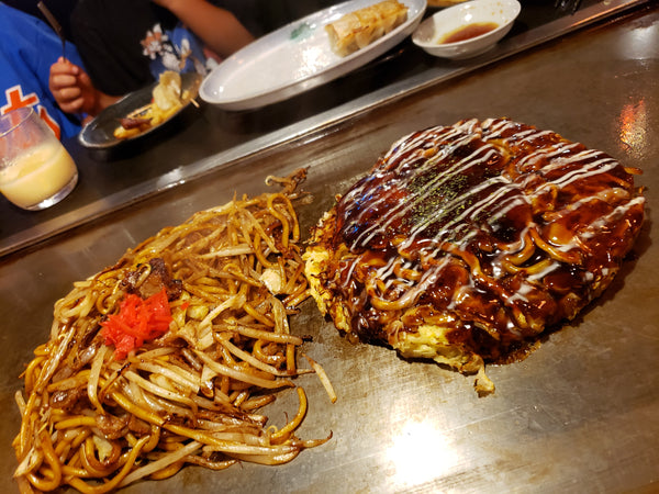 Delicious okonomiyaki pancakes frying on a grill