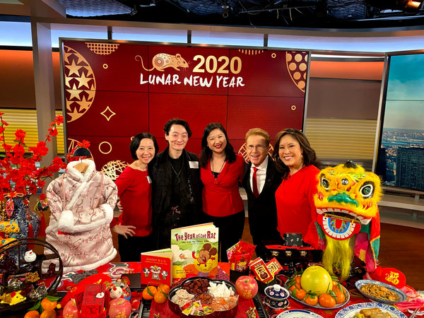 Joanne Kwong and Pearl River staff with CBS's Cindy Hsu and John Elliott in front of display of Lunar New Year decor and foods
