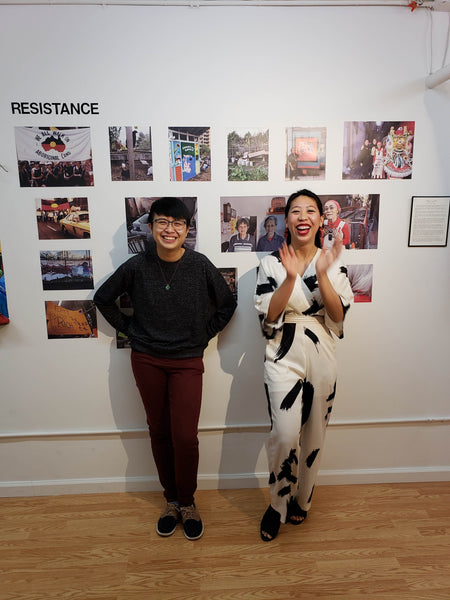 Former artists-in-residence Huiying B. Chan and Diane Wong in front of their photographs of different Chinatowns around the world